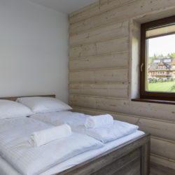 Apartament Słoneczny 12 - sypialnia z łóżkiem małżeńskim i wyjściem na balkon